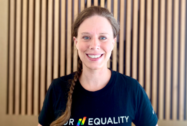 woman with braid in an equality t-shirt smiles