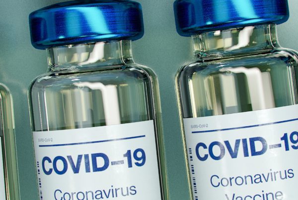 4 vaccine vials with "COVID-19 Coronavirus Vaccine" on label