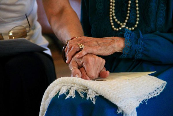 older people hold hands
