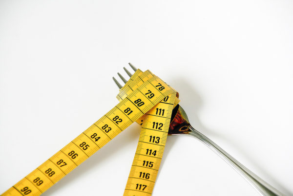 tape measure wrapped around a fork on a white background