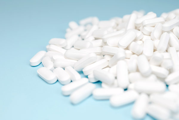 pile of white pills with a blue background