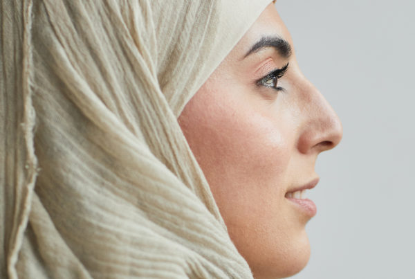 side profile of a woman in a cream colored hijab