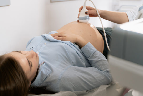 pregnant woman laying down on a table while receiving an ultrasound