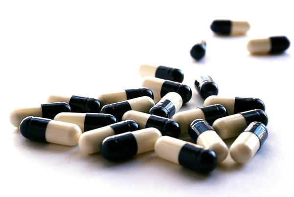 cream and black capsule pills on a white background