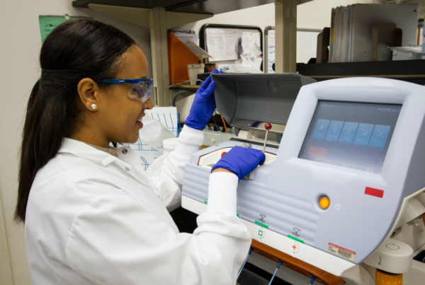 lab technician working on cancer screening machine