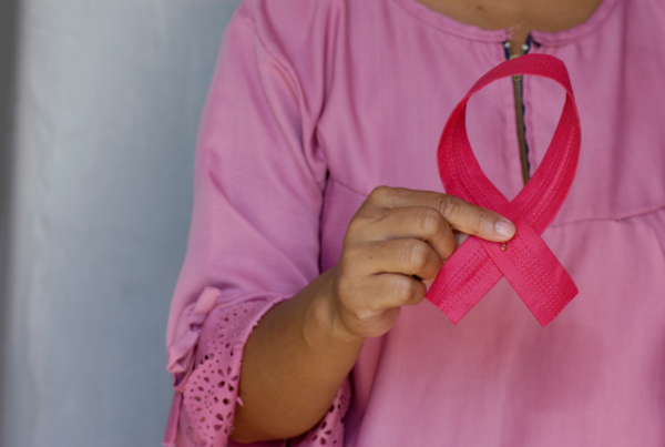 woman holding pink breast cancer ribbon